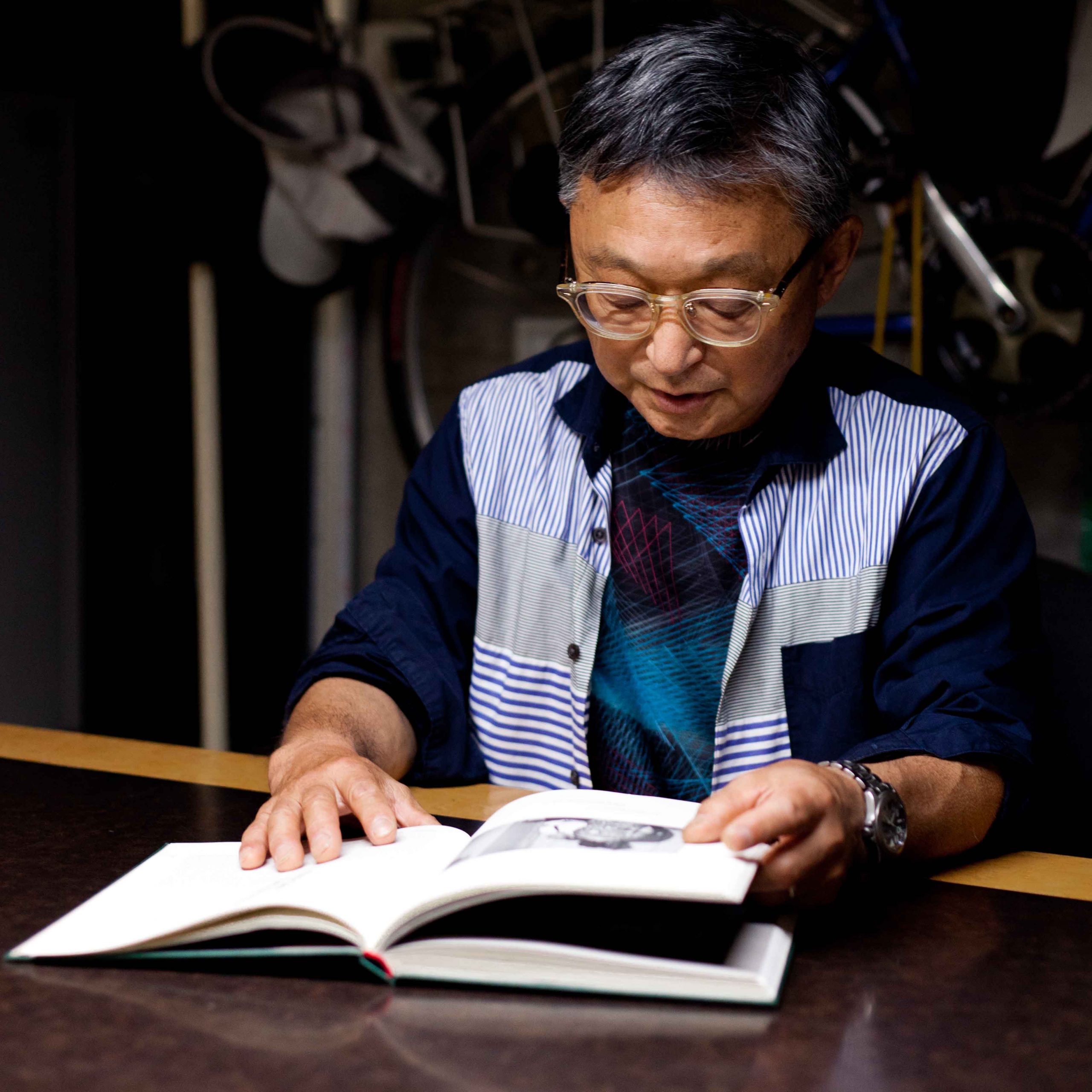 Japanese photographer reading the book the tattoo writer at his home in Tokyo 2023